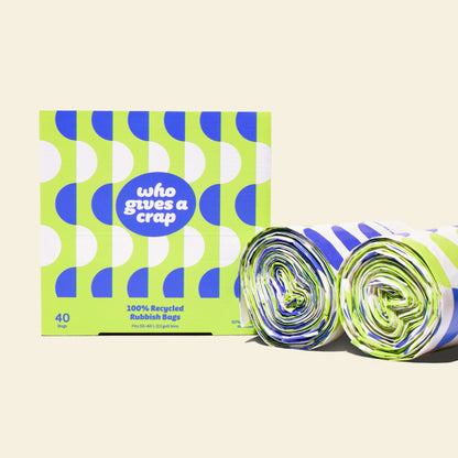 Two rolls and a box of Who Gives a Crap large recycled trash bags with green and blue packaging