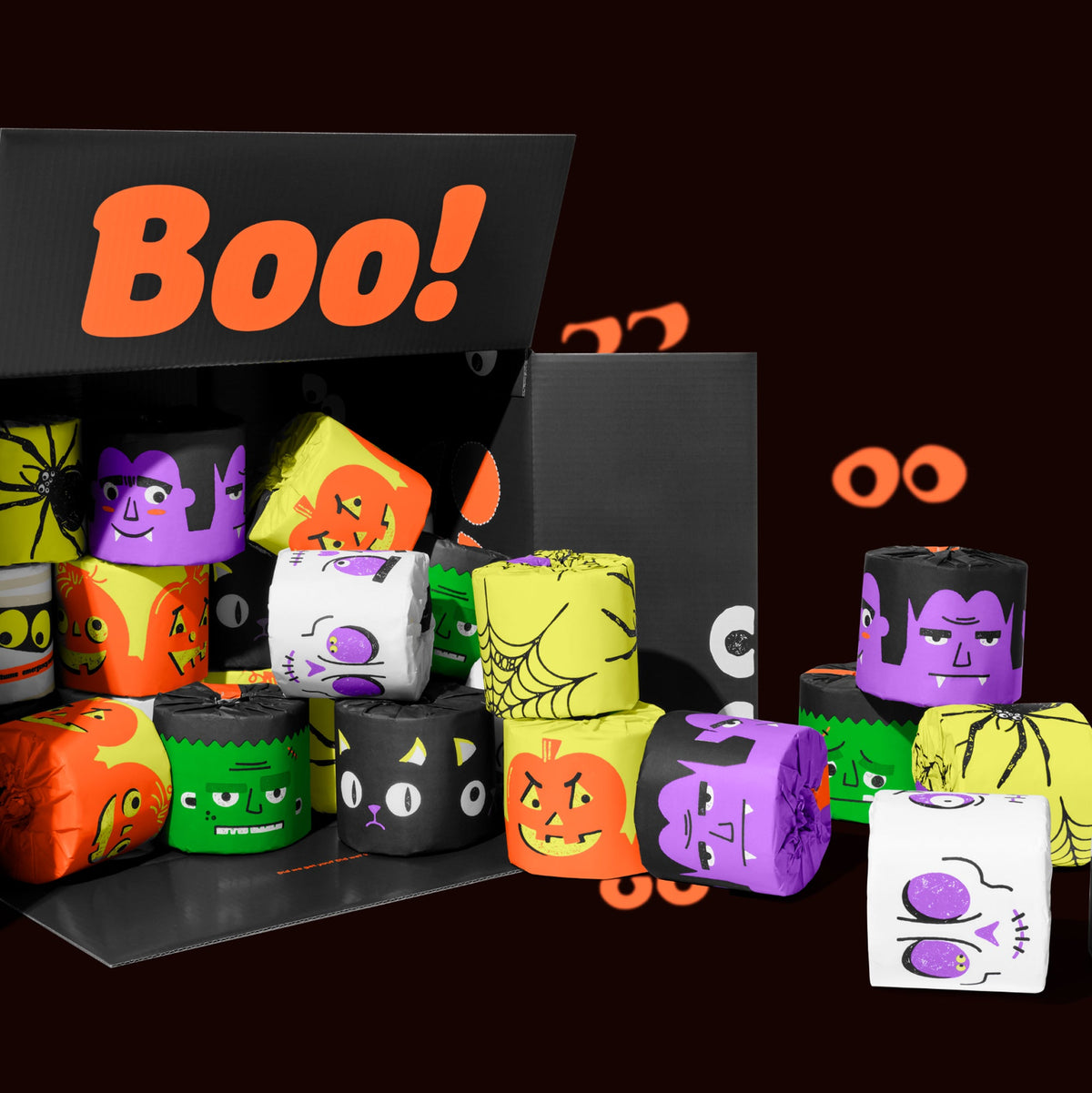 Open black box packed with Halloween-printed bamboo toilet paper rolls in orange, purple, green and white. Box reads "Boo!" on the inside of the box.