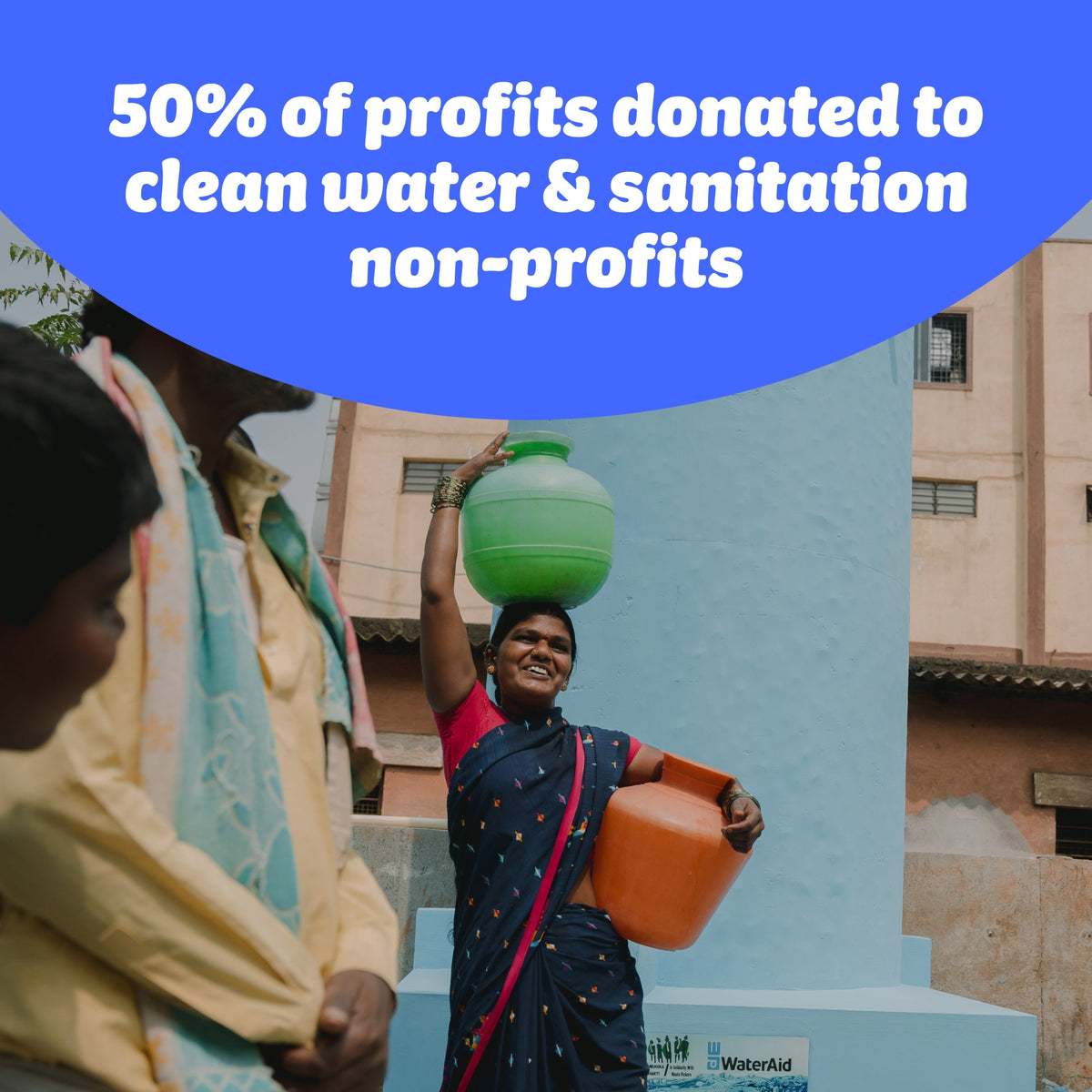Walking woman carries containers of water on head and hip and smiles. Image by WaterAid (Abhijit). Who Gives A Crap donates 50% of profits to clean water & sanitation non-profits.