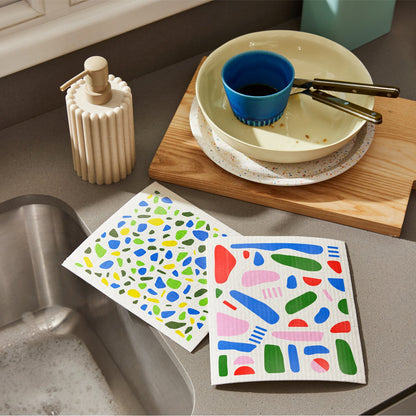 Two Who Gives a Crap colourful dream cloths sitting on kitchen sink next to dirty dishes